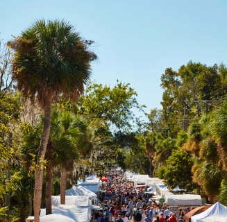 large group of people walking through tents set up