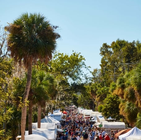 large group of people walking through tents set up 