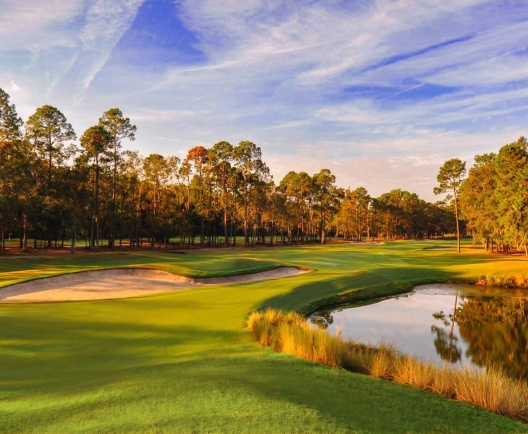 golf course at dusk with a pond and sand bunkers in view