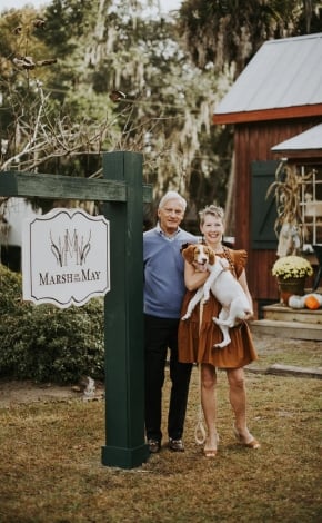 cople standing outside with their dog