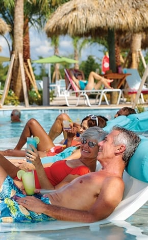 People lounging in a pool on a sunny day