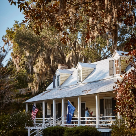 exterior of a house with a large deck and tall trees surrounding